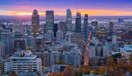 Beleuchtete Skyline von Montréal bei Abenddämmerung, ein Highlight auf Singlereisen im Osten Kanadas.