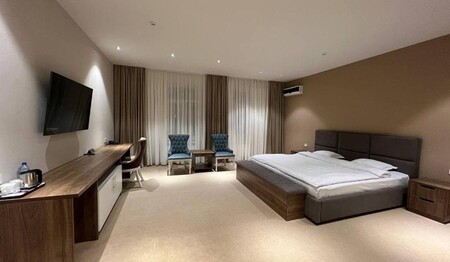 Ein großes, klimatisiertes Zimmer im Hotel Pana in Nukus mit Schreibtisch, Fernseher und Sitzgelegenheiten für Singles & Alleinreisende.
