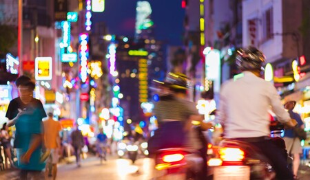 Singlereisen in Vietnam: Das lebhafte Treiben in den Straßen Saigons bei Nacht mit Lichtern und Motorrollern – ideal für Singles & Alleinreisende.