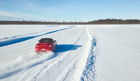 Roter Porsche driftet über den zugefrorenen See in Schwedisch-Lappland für Singles & Alleinreisende.