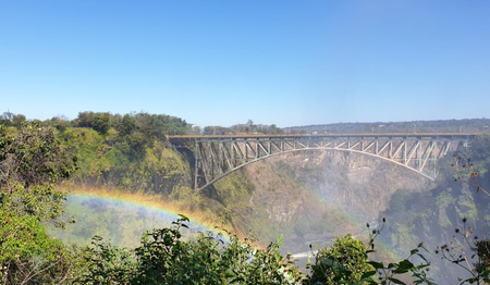 Historische Victoria Falls Bridge mit Regenbogen in der Schlucht: Singles & Alleinreisende buchen bei singlereisen.de