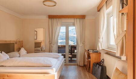 Zimmer mit Zirbenholzbett und Holzboden im Hotel Adler – Singlereise Südtirol