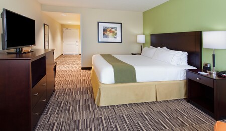 Geräumiges Hotelzimmer mit großem Bett, Flachbild-TV und Kommode im Holiday Inn Express Huntsville auf Kanada-Singlereisen.
