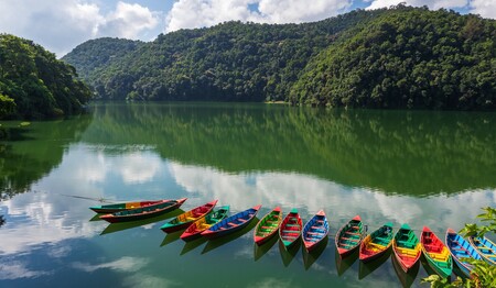 Nepal Singlereisen: Farbenfrohe Boote auf dem Phewa-See vor der Kulisse des Himalaya