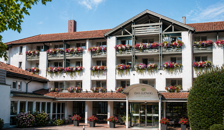 Die blumengeschmückte Außenansicht des Hotels DAS LUDWIG im idyllischen Rottal