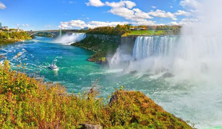 Spektakulärer Panoramablick über die kanadischen Niagarafälle unter wolkenlosem Himmel auf einer Gruppenreise für Singles.