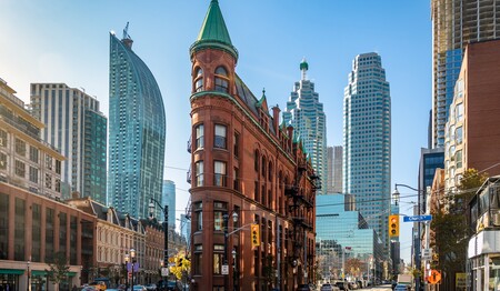 Das historische Gooderham Flatiron Building vor der Kulisse moderner Wolkenkratzer in Toronto auf Kanada-Singlereisen.
