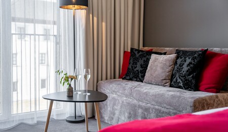 Stilvolle Sitzecke im Hotelzimmer mit zwei Sektgläsern auf dem Beistelltisch für Singles & Alleinreisende beim Genusswandern in Österreich.