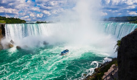 Ausflugsboot im schäumenden Wasser vor den gewaltigen Niagarafällen, ein Höhepunkt für Kanada-Singlereisen.