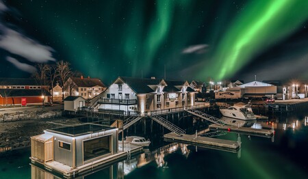 Das historische Restaurant Børsen Spiseri direkt am Wasser unter strahlenden Polarlichtern im Singleurlaub in Norwegen.