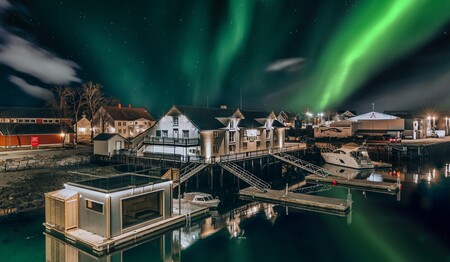 Das historische Restaurant Børsen Spiseri direkt am Wasser unter strahlenden Polarlichtern im Singleurlaub in Norwegen.