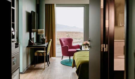 Gemütliche Sitzecke am großen Fenster im modernen Superior-Zimmer während der Reise für Singles.