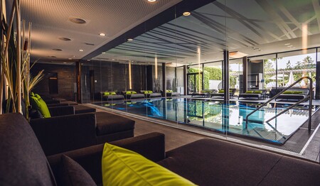 Luxuriöser Hallenbad-Bereich mit großem Pool und bequemen Relax-Liegen zum Entspannen während der Genusswander-Reise.