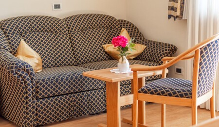 Zimmer mit mit Sitzgelegenheit und Holzboden im Hotel Adler – Singlereise Südtirol