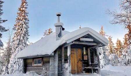 Verschneite Holzhütte in Schwedisch-Lappland bei Singlereisen für Singles & Alleinreisende.