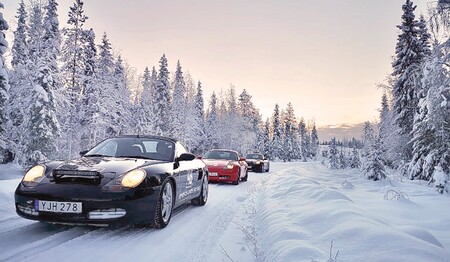Sportwagen fahren hintereinander durch verschneiten Winterwald in Schwedisch-Lappland für Singles & Alleinreisende.