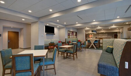 Frühstücksraum mit Tischen und Stühlen im Hotel Hampton Inn by Hilton Brockville für Singlereisen.