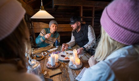 In einer historischen Holzhütte probiert die Singlegruppe bei Kerzenschein typisch norwegische Spezialitäten und erfährt Details zur Kultur.