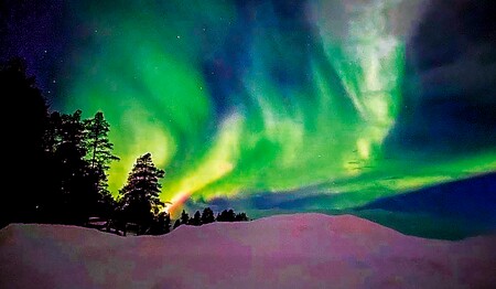 Leuchtend grüne Polarlichter am Nachthimmel über Schwedisch-Lappland für Singles & Alleinreisende.
