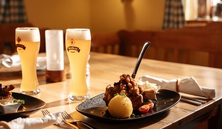 Traditionelle bayerische Spezialitäten und frisch gezapftes Bier auf den hölzernen Tischen im gemütlichen Weinrestaurant „Zum Heurigen“