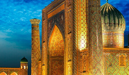 Der prachtvoll beleuchtete Registan-Platz in Samarkand am Abend, ein Höhepunkt der Singlereisen und Kultur-Rundreise Usbekistan.